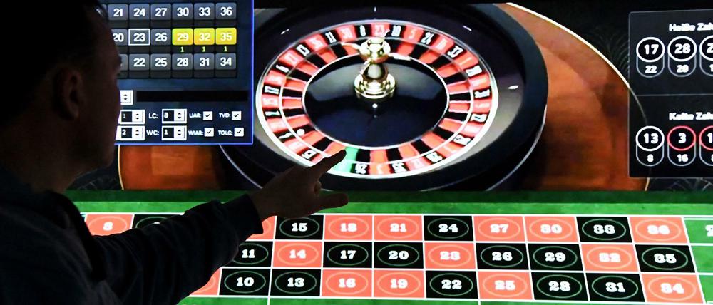 Ein Mann spielt an einem Bildschirm Online-Roulette.