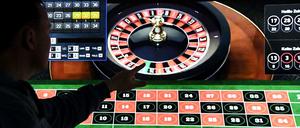Ein Mann spielt an einem Bildschirm Online-Roulette.