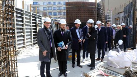 Rabbiner Yehuda Teichtal (2.v.l.) führt Michael Müller (l.) über die Baustelle.