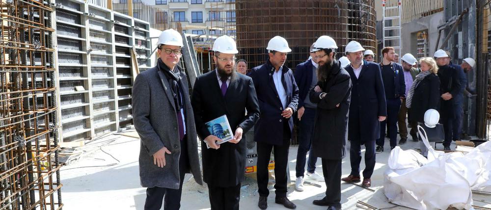 Rabbiner Yehuda Teichtal (2.v.l.) führt Michael Müller (l.) über die Baustelle.
