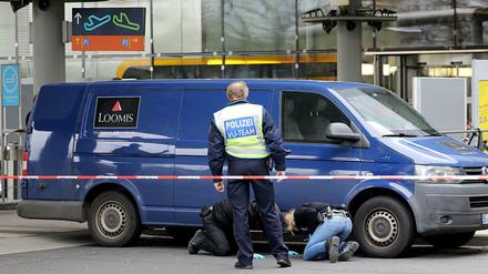 Ermittler der Polizei sichern an dem Geldtransporter am Flughafen Köln/Bonn Spuren.