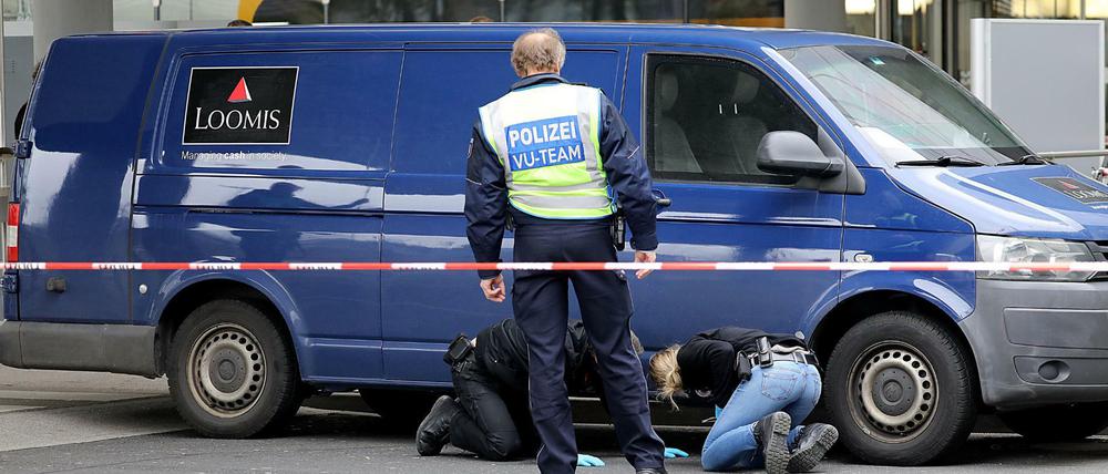 Ermittler der Polizei sichern an dem Geldtransporter am Flughafen Köln/Bonn Spuren.