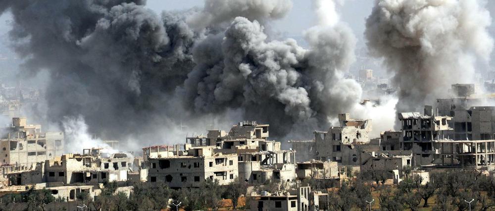 Rauch steigt nach dem Einschlag einer Rakete der syrischen Armee über Duma auf.