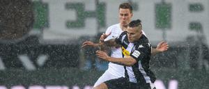 Gladbachs Raul Bobadilla (rechts) und Bremens Niklas Moisander kämpfen im Schneetreiben um den Ball.
