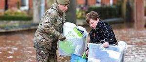 Ein Soldat hilft einer Frau in Carlisle. 