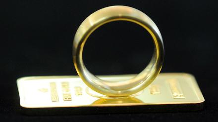Ein Goldring auf einem kleinen Goldbarren.