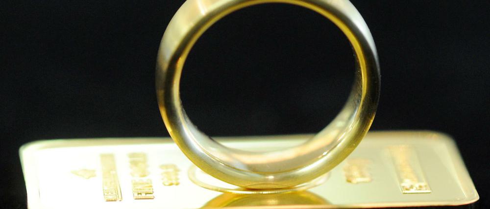 Ein Goldring auf einem kleinen Goldbarren.