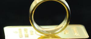 Ein Goldring auf einem kleinen Goldbarren.