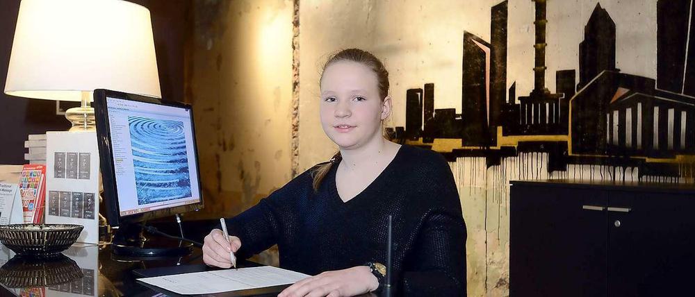 Schülerin Emilia bei ihrem Praktikum an der Hotelrezeption.