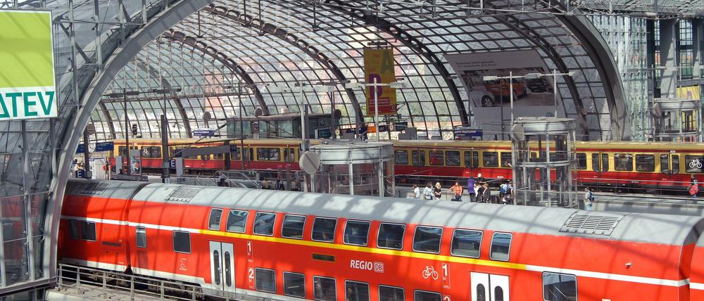 Im Berliner Hauptbahnhof stehen eine S-Bahn und ein Regionalzug. 