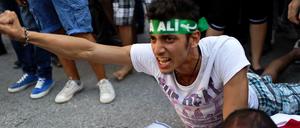 Syrische Demonstranten liegen vor einem Bild des syrischen Präsidenten Assad auf dem Boden. Sie protestieren gegen den geplanten Militäreinsatz der USA.