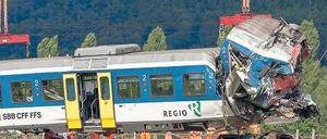 Aufräumarbeiten. Angestellte der Bundesbahn transportieren in Granges-pres-Marnand im Westen der Schweiz das Zugwrack ab, damit es in der Werkstatt zerlegt werden kann. Foto: dpa