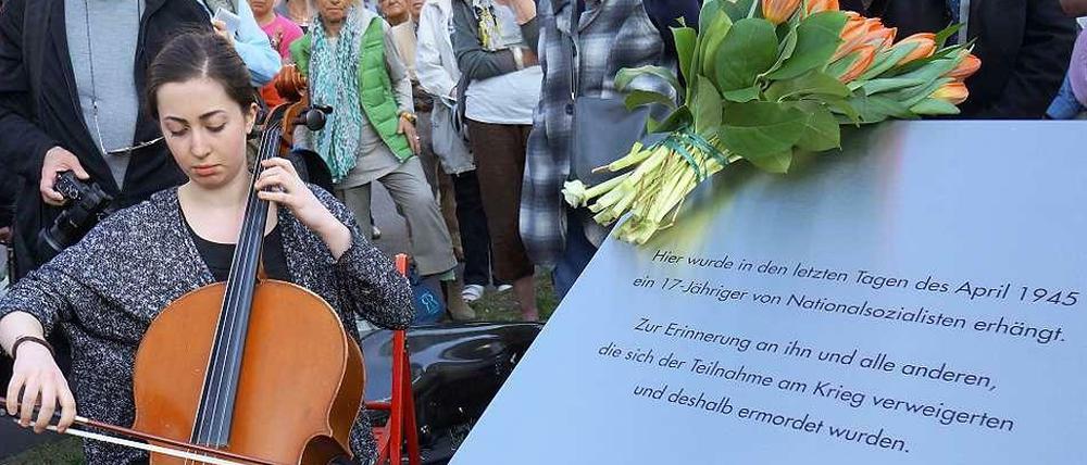 Erinnerung an ermordete Kriegsverweigerer. Neben der neuen Gedenktafel in der Uhlandstraße musizierte Elia Cohen-Weissert.