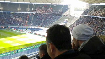 Gegentribüne (Nord) Oberring, Block 28.1. Gebannt verfolgen die beiden Männer die Bundesliga-Partie Hertha BSC gegen den 1. FC Köln.