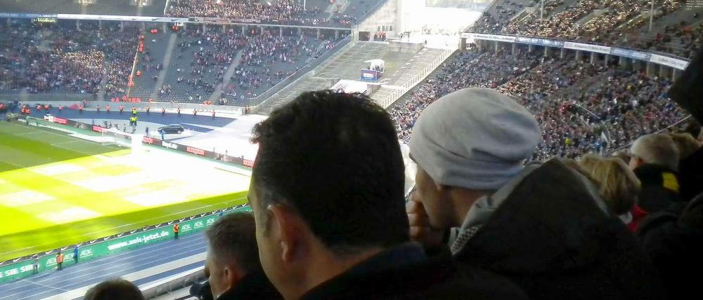 Gegentribüne (Nord) Oberring, Block 28.1. Gebannt verfolgen die beiden Männer die Bundesliga-Partie Hertha BSC gegen den 1. FC Köln.
