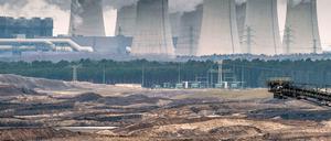 Blick über Abraumhalden des Jänschwalder Braunkohletagebaus auf die qualmenden Kühltürme des Braunkohlekraftwerkes von Vattenfall.