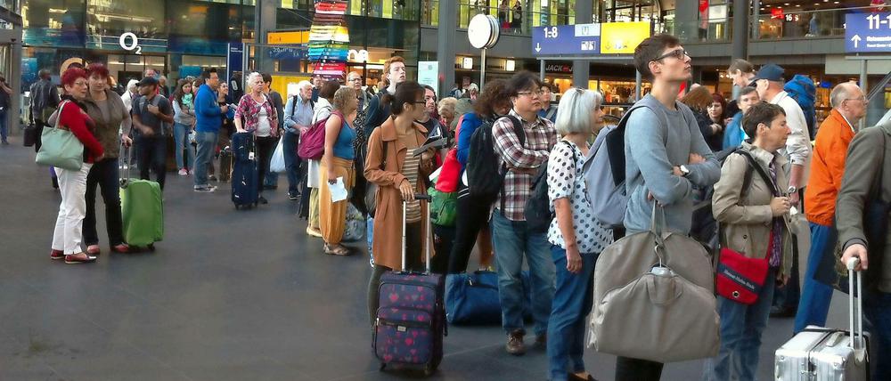 Die Wartenden in der Schlange am Infoschalter - um kurz vor acht Uhr am Hauptbahnhof Berlin.