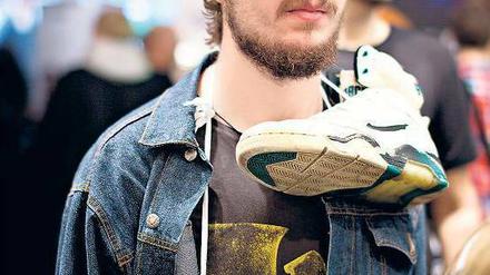 Die Sneakers am Herzen - ein Kenner in Jeanshemd, Mütze und mit sorgfältig gezotteltem Bart. 