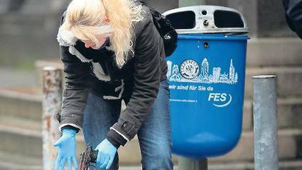 Rache nach Mord wegen Parkplatzes. Eine Beamtin sichert die Waffe. Foto: dpa