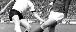 Souvenirjäger. Helmut Haller (l.) trifft an Bobby Moore vorbei. Das WM-Finale 1966 verlor er, den Ball aber behielt er. Foto: dpa