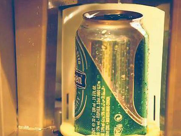 Eine Bierdose steht mit Wassertropfen auf der Oberfläche in einem grauen Halter
