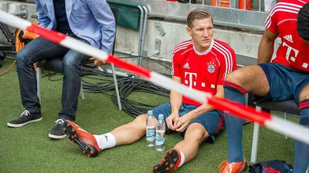 Bastian Schweinsteiger sitzt hinter einem Absperrband auf der Ersatzbank.