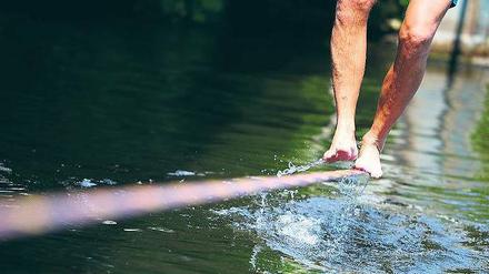 Zu Fuß. Beim Balancieren auf dem durchhängenden Gurt, der Slackline, trainiert man seine Körperkoordination.  
