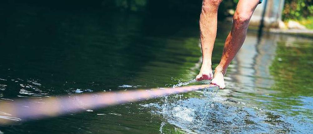 Zu Fuß. Beim Balancieren auf dem durchhängenden Gurt, der Slackline, trainiert man seine Körperkoordination.