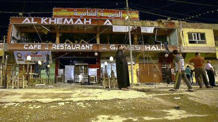 Irakische Männer inspizieren die Verwüstungen, die das Bombenattentat am 17. Mai 2013 in Fallujah hinterlassen hat.