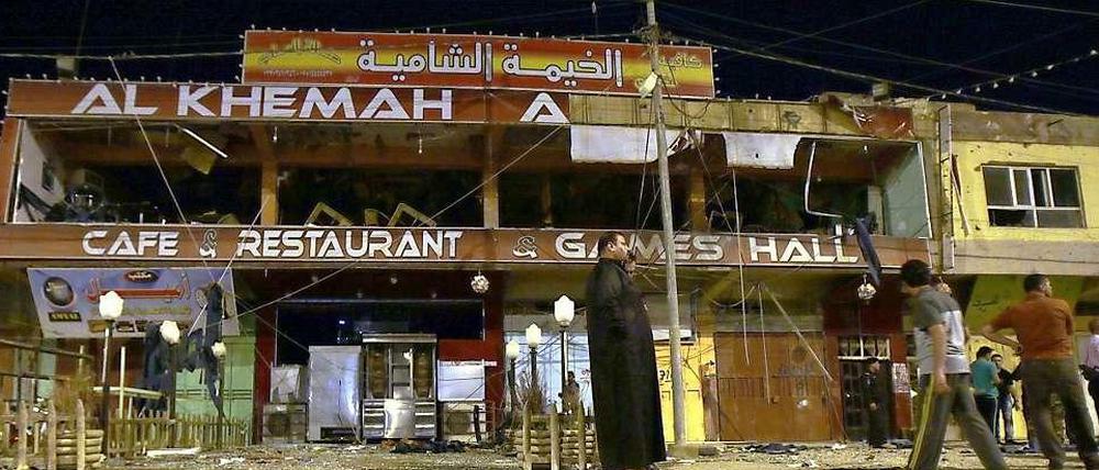 Irakische Männer inspizieren die Verwüstungen, die das Bombenattentat am 17. Mai 2013 in Fallujah hinterlassen hat.