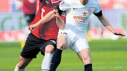 Rangeln auf Rasen. Hannovers Christian Schulz (l.) kämpft mit Nicolai Müller um den Ball. Der Mainzer Angreifer war mit seinen zwei Toren der überragende Spieler der Bundesligapartie.