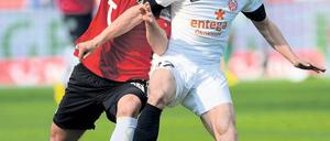 Rangeln auf Rasen. Hannovers Christian Schulz (l.) kämpft mit Nicolai Müller um den Ball. Der Mainzer Angreifer war mit seinen zwei Toren der überragende Spieler der Bundesligapartie.