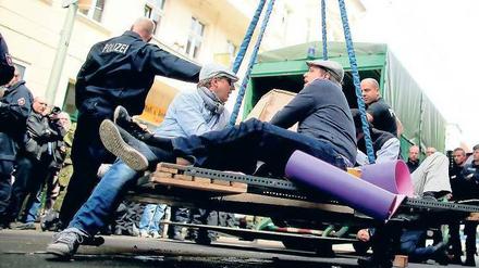 Schwere Technik. Polizisten räumen mittels Kran vier Männer von der Straße, die sich an einer Betonpyramide angekettet hatten. Wenigstens diese zeitweilige Blockade gelang den Nazigegnern. 