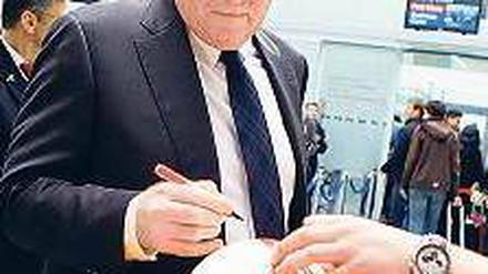 Ablenkung. Vor dem Flug nach Barcelona schrieb Hoeneß Autogramme. Foto: Reuters