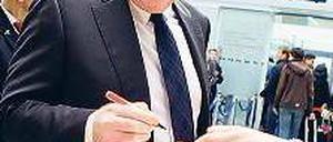 Ablenkung. Vor dem Flug nach Barcelona schrieb Hoeneß Autogramme. Foto: Reuters