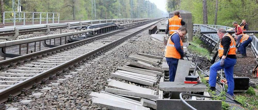 Arbeiter beheben den Schaden nach einem Kabelbrand an der S-Bahnstrecke zwischen Grunewald und Wannsee..