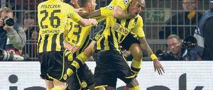 Siegtorschütze im Würgegriff. Dortmunds Spieler bedanken sich auf nicht ganz zärtliche Weise bei Felipe Santana, der mit seinem Tor in der dritten Minute der Nachspielzeit eine denkwürdige Begegnung entschieden hat. Foto: AFP