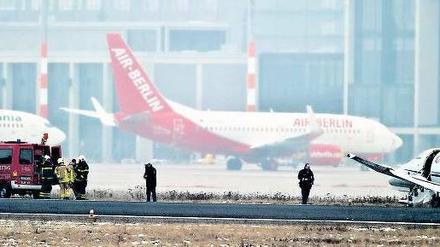 Am Unfallort. Rettungskräfte eilten zum Flugzeug, das ins Gras gerutscht war. Im Hintergrund ist der neue BER-Terminal zu erkennen. Foto: dpa