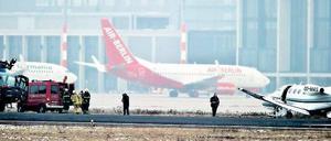 Am Unfallort. Rettungskräfte eilten zum Flugzeug, das ins Gras gerutscht war. Im Hintergrund ist der neue BER-Terminal zu erkennen. Foto: dpa