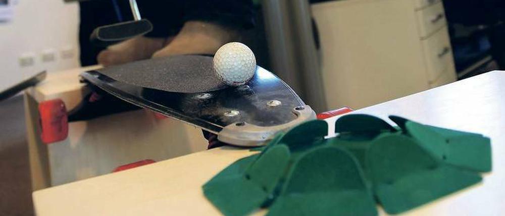 Putt, putt. Beim Bürogolfen ist fast alles erlaubt. Hier testet Kirsten Richerzhagen einen Hindernisparcours auf Büroschränken mit Skateboardbrücke. 