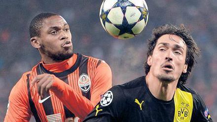 Er ließ den Ball nie aus den Augen. Der Dortmunder Mats Hummels (rechts, im Zweikampf mit Luiz Adriano) war auf beiden Seiten des Spielfelds an den Toren beteiligt. Foto: AFP