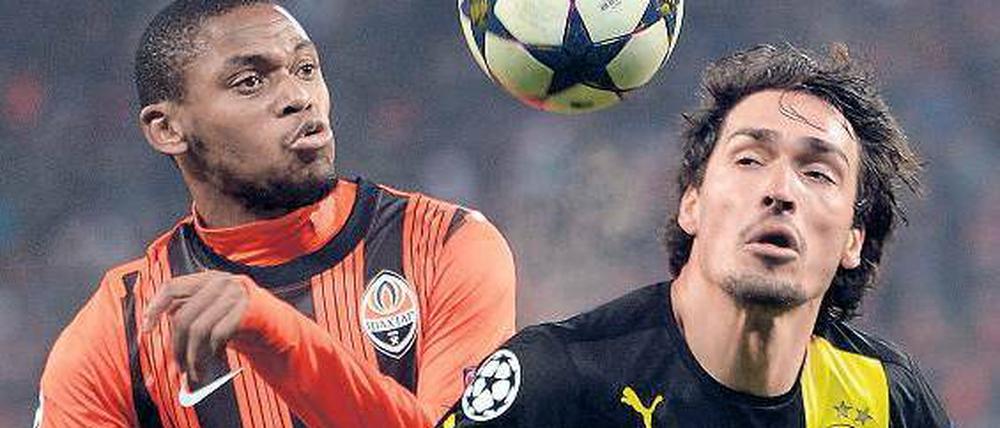 Er ließ den Ball nie aus den Augen. Der Dortmunder Mats Hummels (rechts, im Zweikampf mit Luiz Adriano) war auf beiden Seiten des Spielfelds an den Toren beteiligt. Foto: AFP