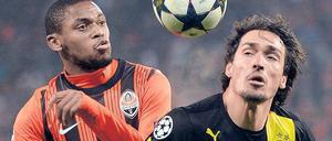 Er ließ den Ball nie aus den Augen. Der Dortmunder Mats Hummels (rechts, im Zweikampf mit Luiz Adriano) war auf beiden Seiten des Spielfelds an den Toren beteiligt. Foto: AFP