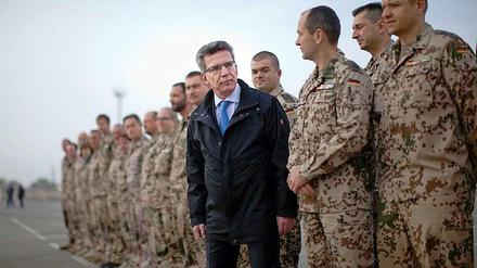 Verteidigungsminister Thomas de Maiziere spricht mit Soldaten in Usbekistan. 