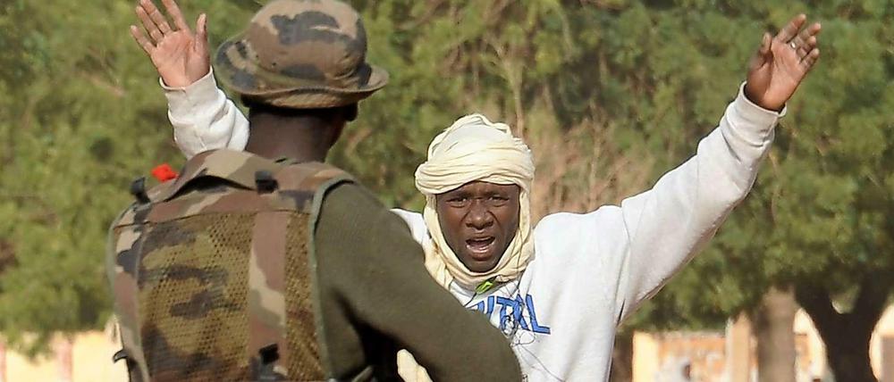 Ein malischer Soldat nimmt an einem Kontrollpunkt in der nordmalischen Stadt Mali einen Mann fest. In Gao war es nach zwei Selbstmordanschlägen zu heftigen Kämpfen gekommen. Die malischen Soldaten gehen nach Angaben der französischen Armee von Haus zu Haus, um Islamisten zu finden.