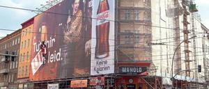Es werde Licht. Am Mittwoch fotografierten Berliner und Touristen noch die Fassadenkletterer, die den Werbeslogan zur Entschuldigung umklebten. Wegen des Plakates für Coca-Cola hatte Fernando Rossi (o.r.) tagelang eine verhängte Sicht. Noch am gestrigen Abend wollte der Softdrinkkonzern das umstrittene Poster an der Danziger Straße 2 abhängen. Fotos: Georg Moritz
