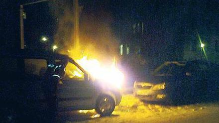 17.33 Uhr. Ein Polizist geht direkt an das Auto heran und sieht durch die Beifahrertür ins Innere. Löschversuche unternimmt er lieber nicht.