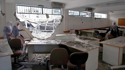 Mädchen im Gazastreifen betrachten ihre zerstörte Schule.
