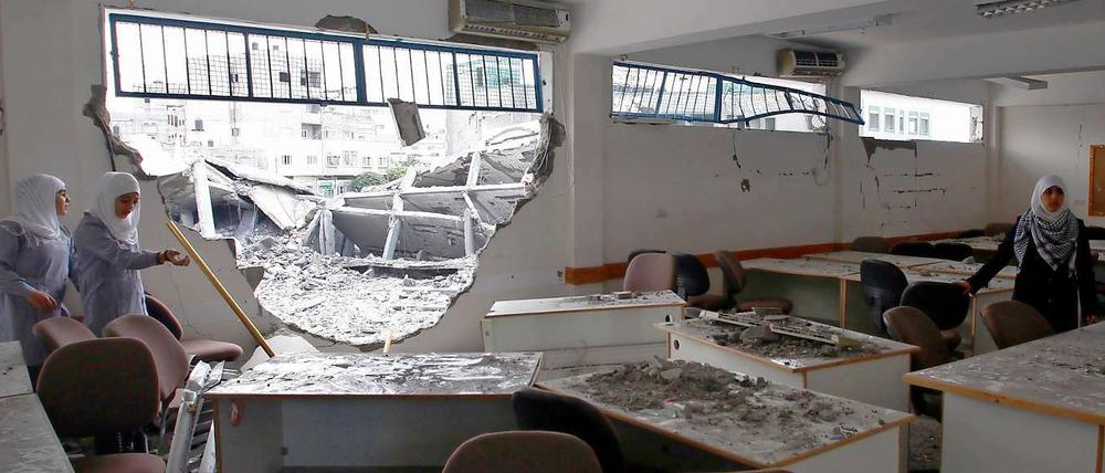 Mädchen im Gazastreifen betrachten ihre zerstörte Schule.