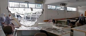 Mädchen im Gazastreifen betrachten ihre zerstörte Schule.